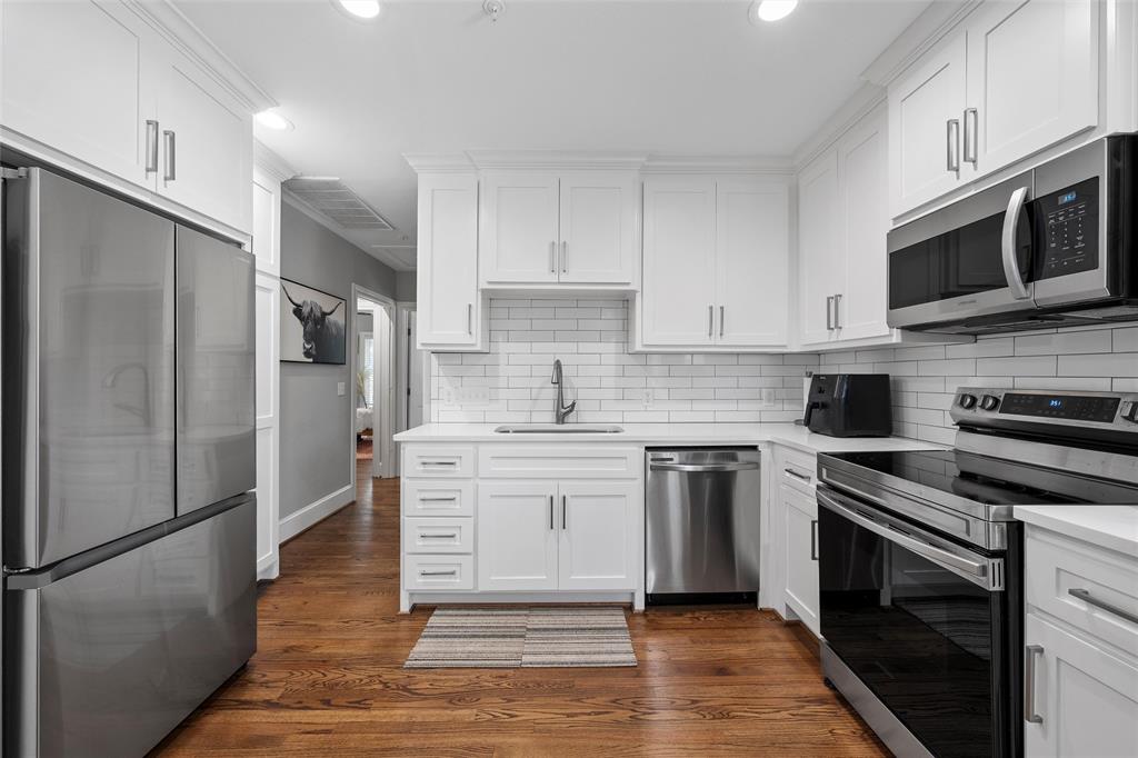 1500 South 10th Street Waco, TX 76706 - Photo 14 of 25 Kitchen featuring appliances with stainless steel finishes, white cabinetry, dark wood finished floors, and recessed lighting