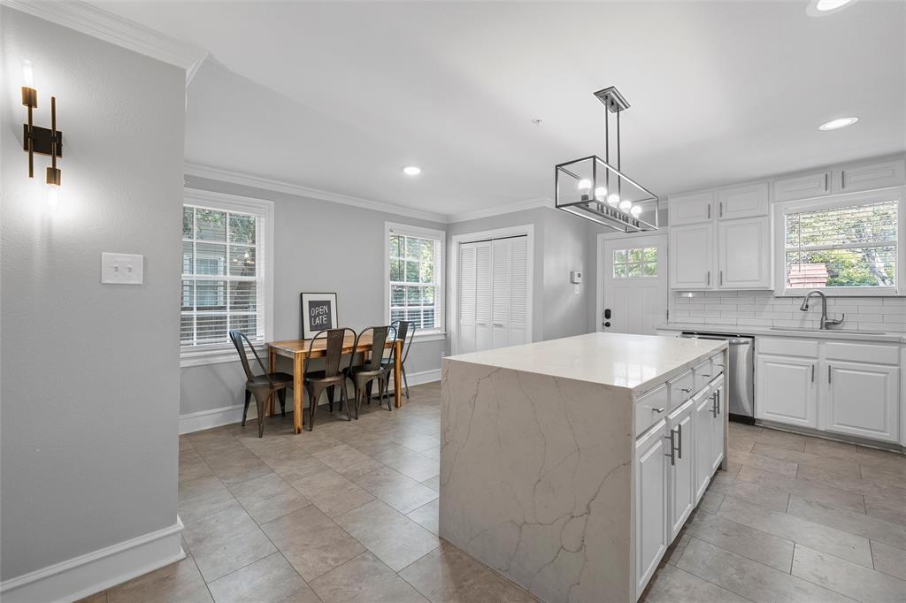 1500 South 10th Street Waco, TX 76706 - Photo 8 of 25 Kitchen with white cabinetry, tasteful backsplash, crown molding, a kitchen island, and plenty of natural light