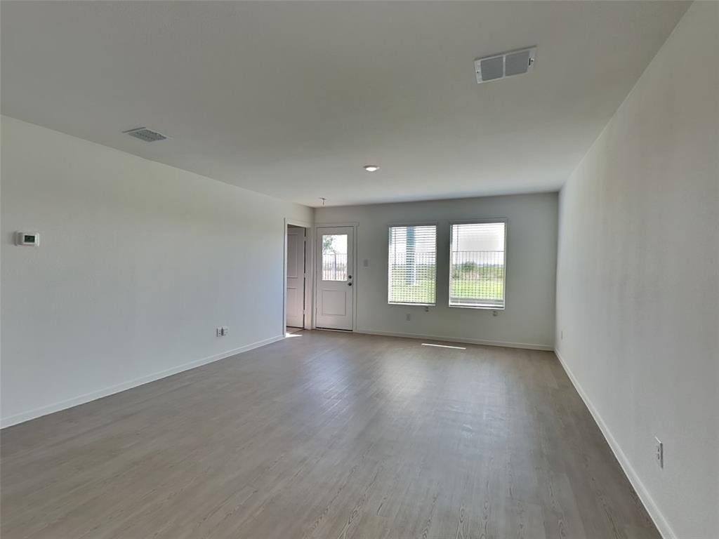 4229 Brindley Road Little Elm, TX 75068 - Photo 2 of 15 an empty room with wooden floor and windows