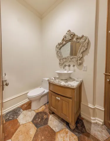 a bathroom with a granite countertop toilet and a mirror