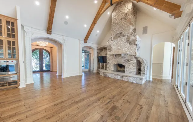 a view of a livingroom with wooden floor and a fireplace