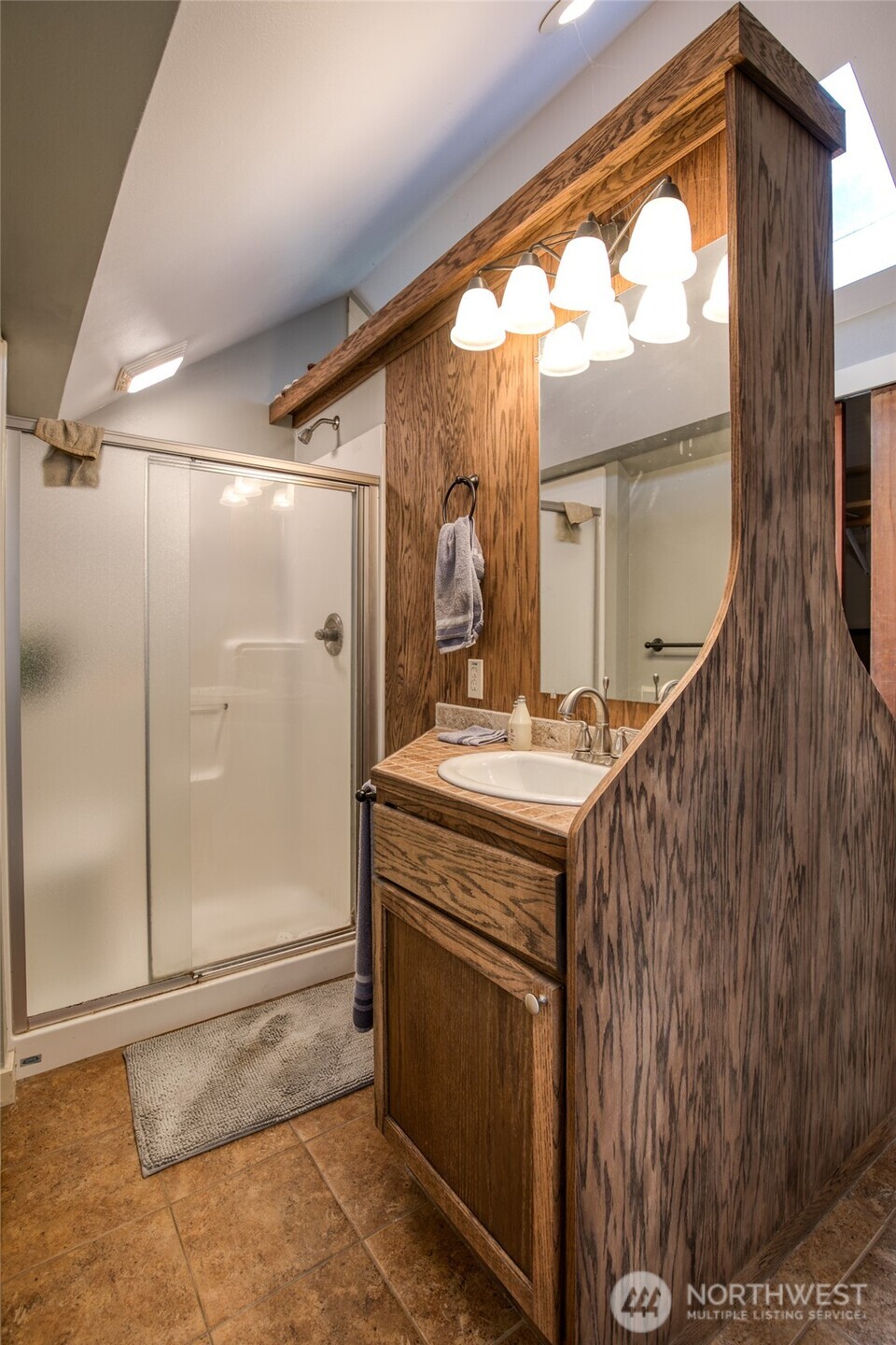 722 7th Avenue Aberdeen, WA 98520 - Photo 24 of 38 a bathroom with a sink a mirror and a shower