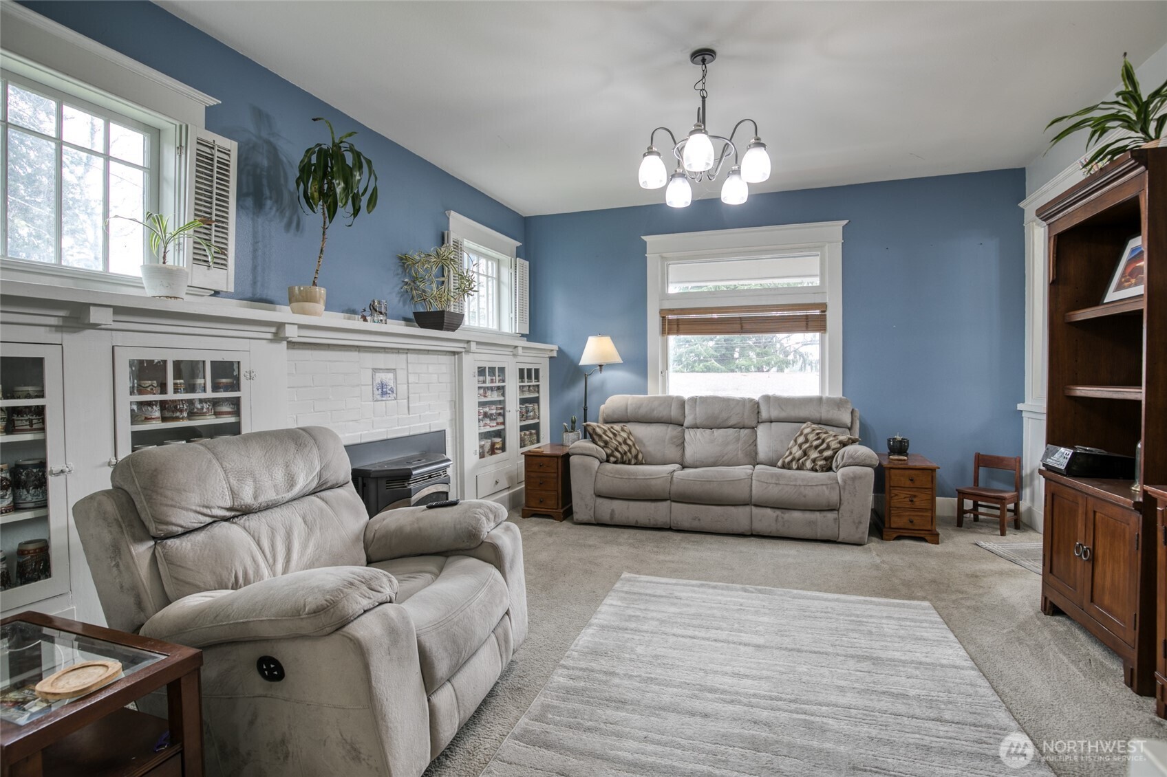 722 7th Avenue Aberdeen, WA 98520 - Photo 7 of 38 a living room with furniture a chandelier and a fireplace