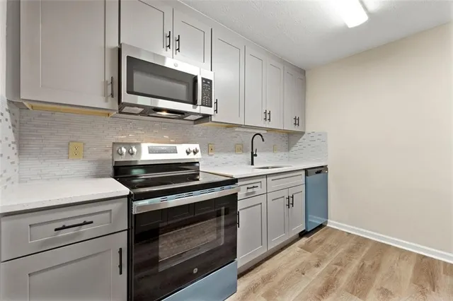 a kitchen with stainless steel appliances granite countertop a sink and a microwave