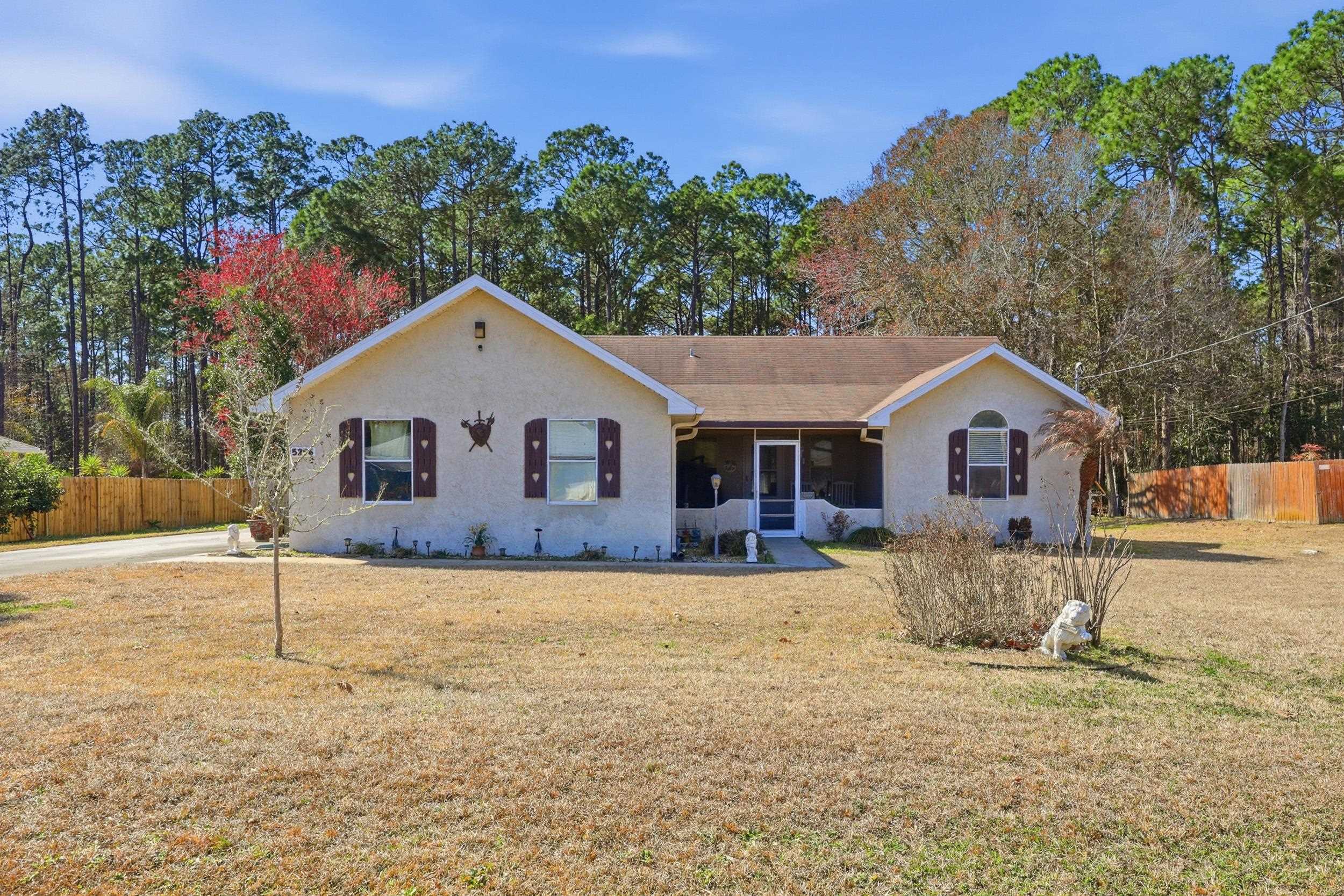5296 Timucua Circle St. Augustine, FL 32086 - Photo 1 of 65 Ranch-style house featuring covered porch and view of wooded area