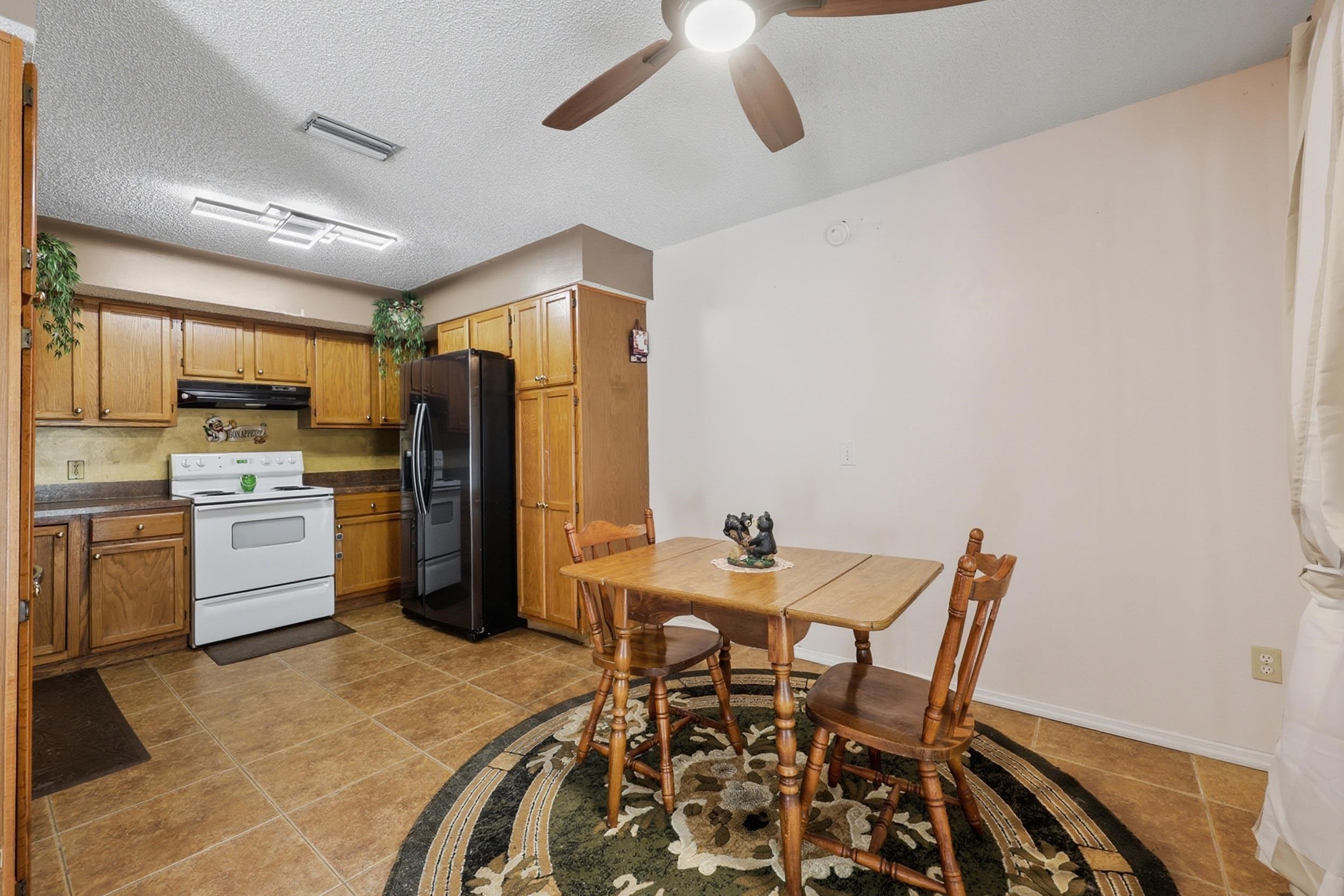 5296 Timucua Circle St. Augustine, FL 32086 - Photo 18 of 65 a kitchen with a table chairs refrigerator and microwave