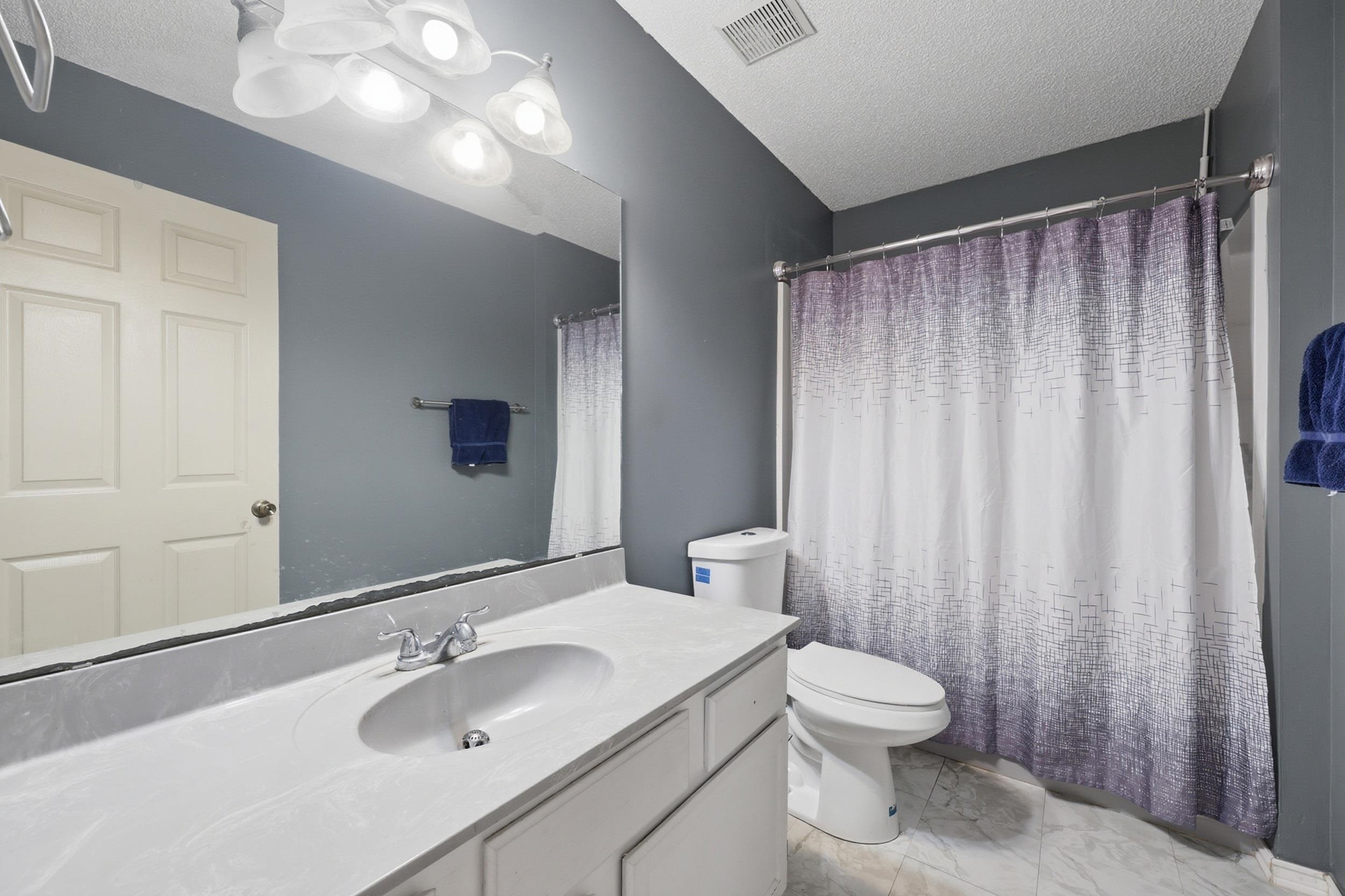 5296 Timucua Circle St. Augustine, FL 32086 - Photo 21 of 65 Full bathroom featuring vanity, a shower with shower curtain, a textured ceiling, and light marble finish floors