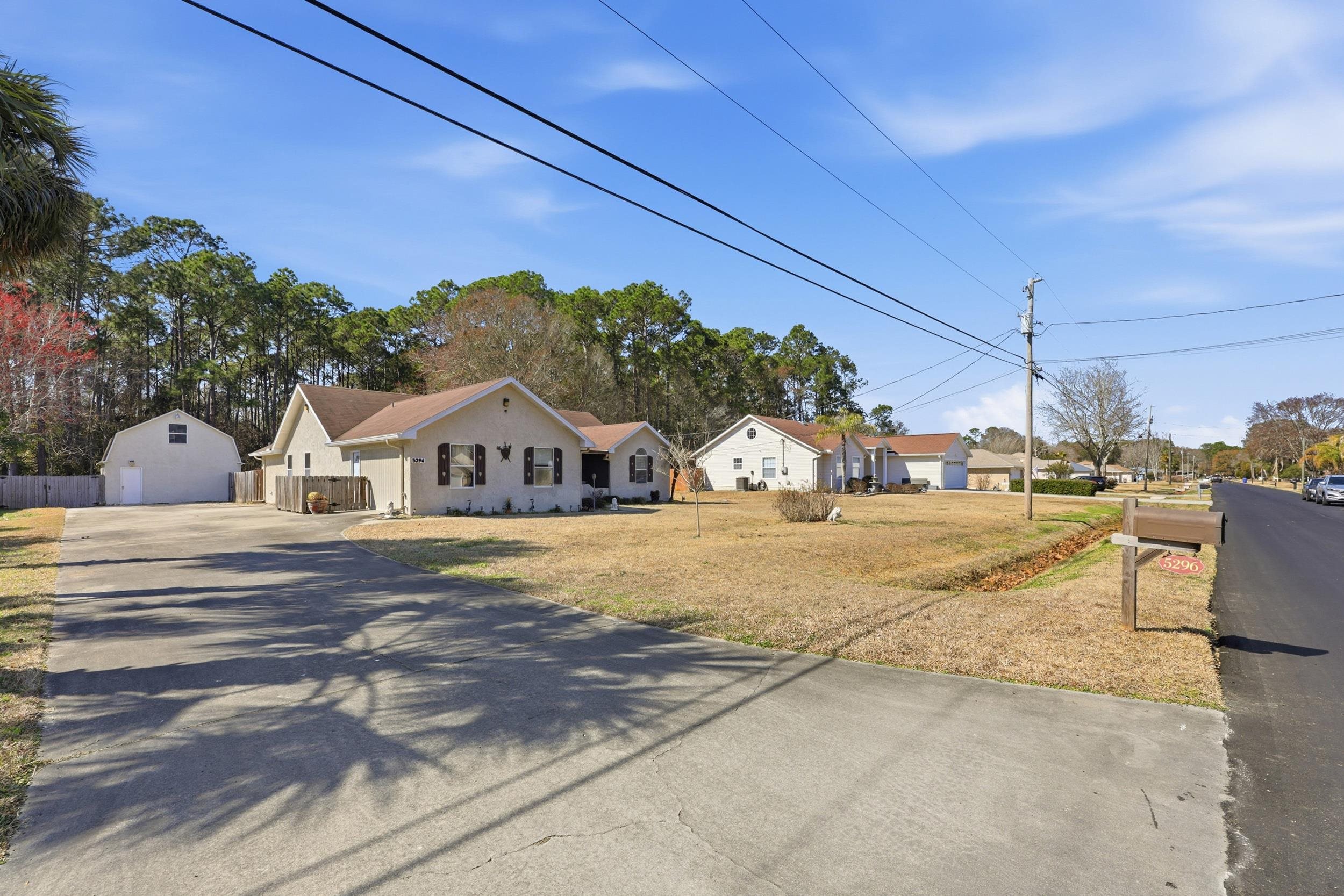 5296 Timucua Circle St. Augustine, FL 32086 - Photo 50 of 65 View of front facade featuring a residential view, an outdoor structure, concrete driveway, and a front yard