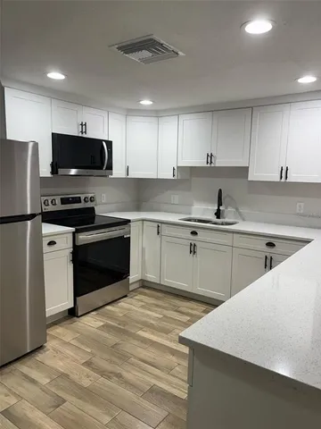 a kitchen with a sink a stove a refrigerator and cabinets