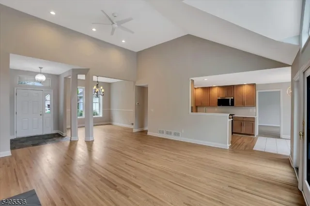 a view of a big room with wooden floor and a kitchen