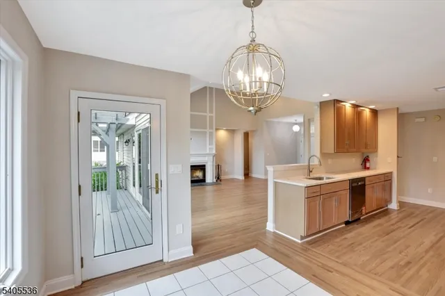 a view of a kitchen with a sink and dishwasher with wooden floor
