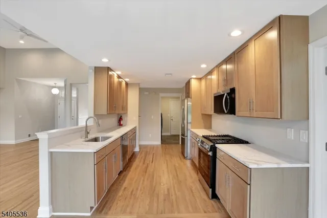 a kitchen with stainless steel appliances a sink stove top oven and cabinets