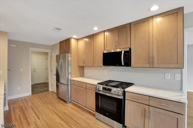 a kitchen with stainless steel appliances a refrigerator stove and microwave