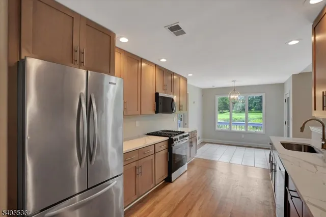 a kitchen with stainless steel appliances a refrigerator sink and cabinets