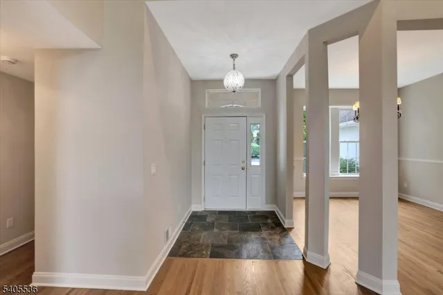 a view of a hallway with wooden floor and a bathroom