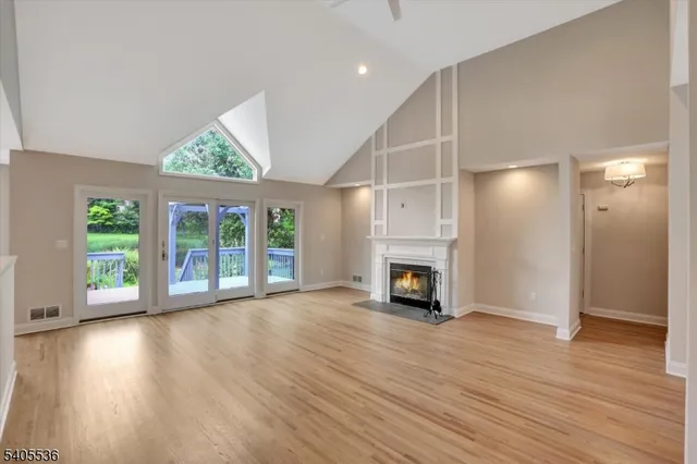 a view of a livingroom with wooden floor a fireplace and window