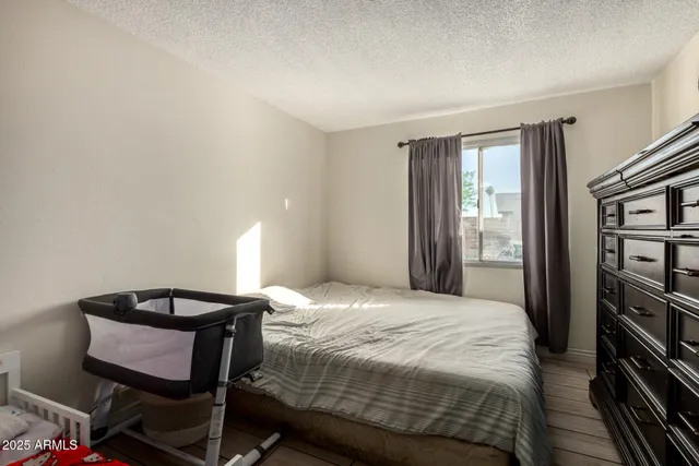 a bedroom with a bed a table and bookshelf