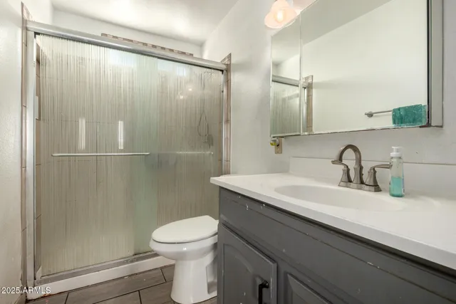 a bathroom with a sink a toilet and shower