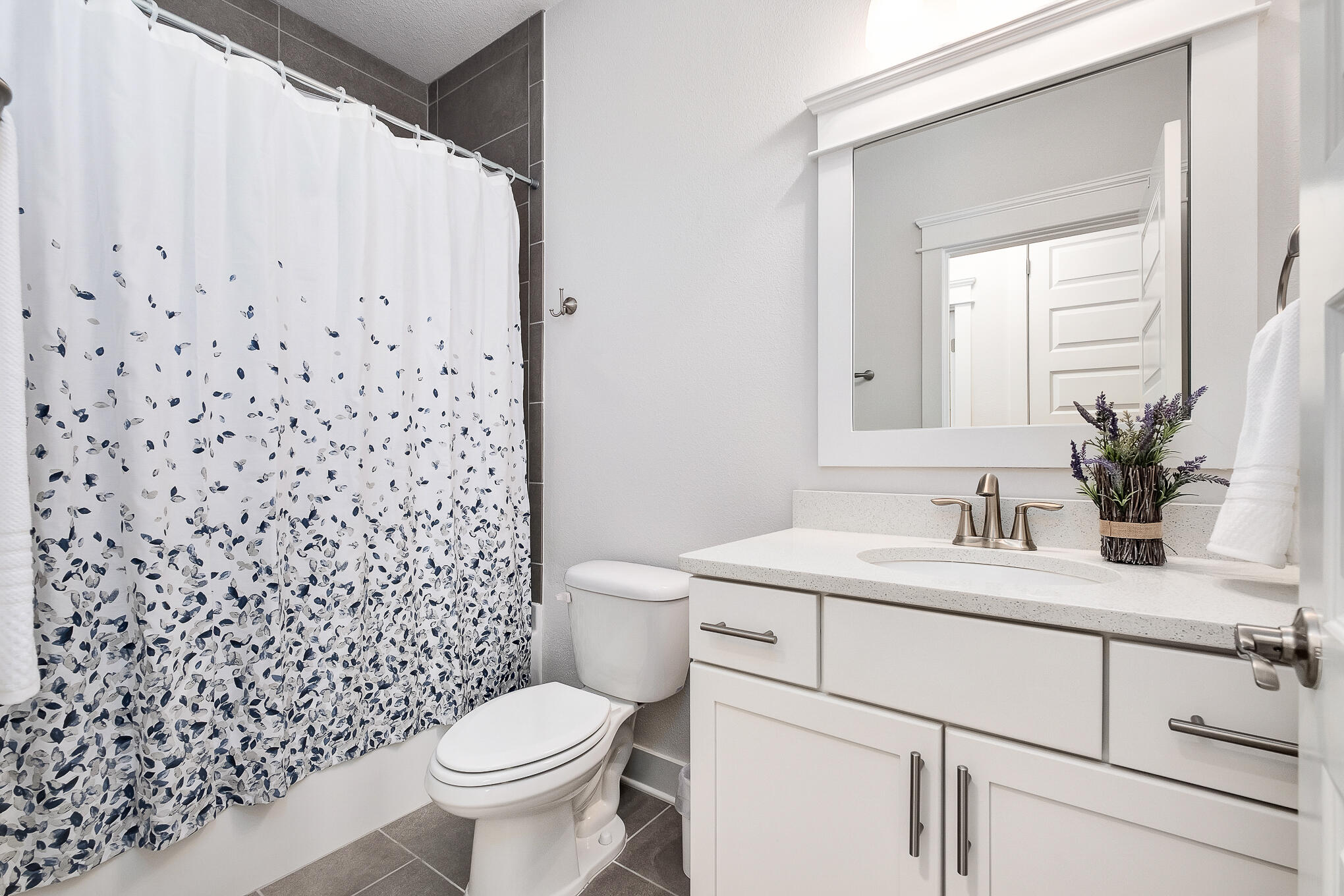 386 Grande Pointe Circle Inlet Beach, FL 32461 - Photo 25 of 50 a bathroom with a granite countertop toilet a sink a mirror and a shower