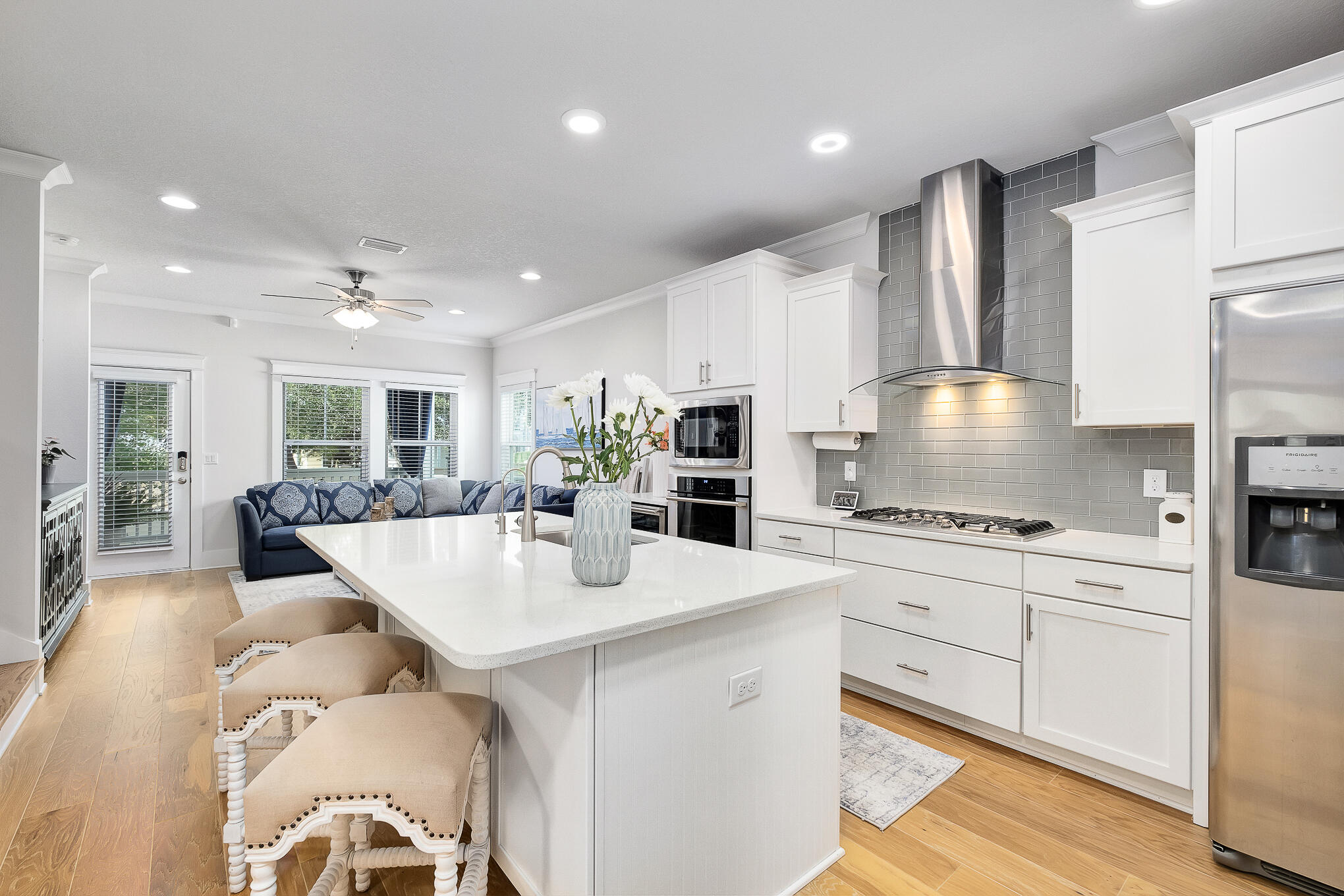 386 Grande Pointe Circle Inlet Beach, FL 32461 - Photo 6 of 50 a large kitchen with kitchen island a stove a sink a refrigerator and white cabinets with wooden floor