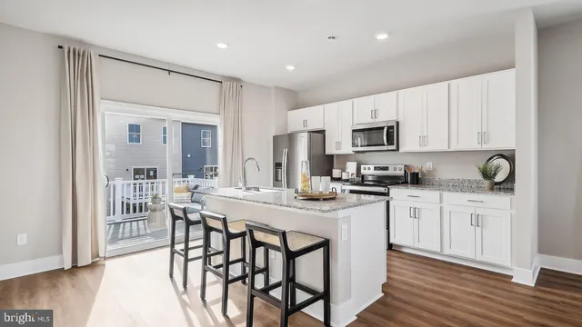 a kitchen with granite countertop white cabinets and stainless steel appliances