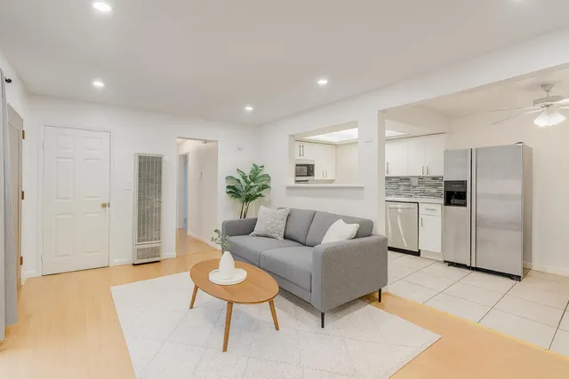 a living room with furniture and a refrigerator