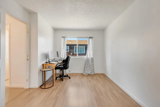 a view of a workspace with furniture and a window