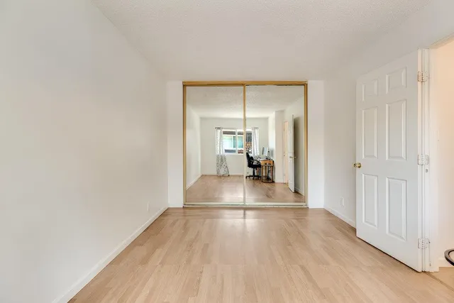 a view of a hallway with wooden floor and a living room