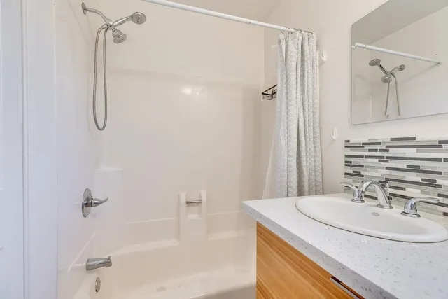 a bathroom with a sink a mirror and a shower