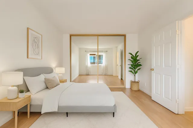 a bedroom with a large bed and a potted plant