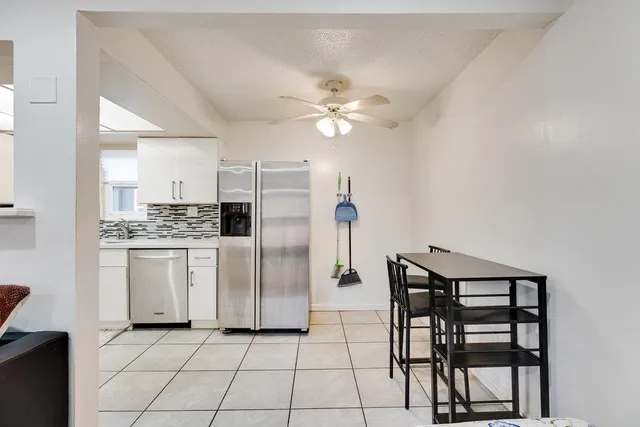 a kitchen with white cabinets and stainless steel appliances