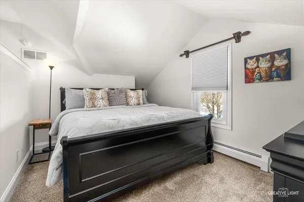 a bed sitting in a bedroom next to a window
