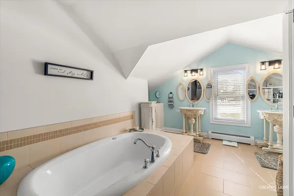 a bathroom with a tub sink and mirror