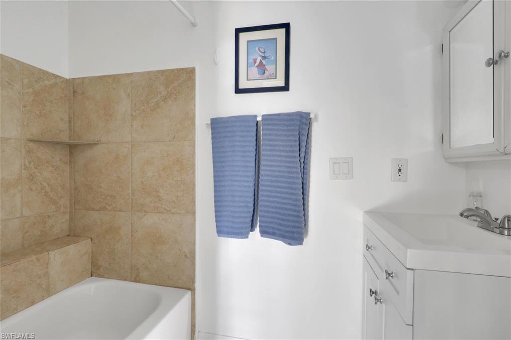 2772 Riverview Drive Naples, FL 34112 - Photo 12 of 23 a bathroom with a tub sink and vanity