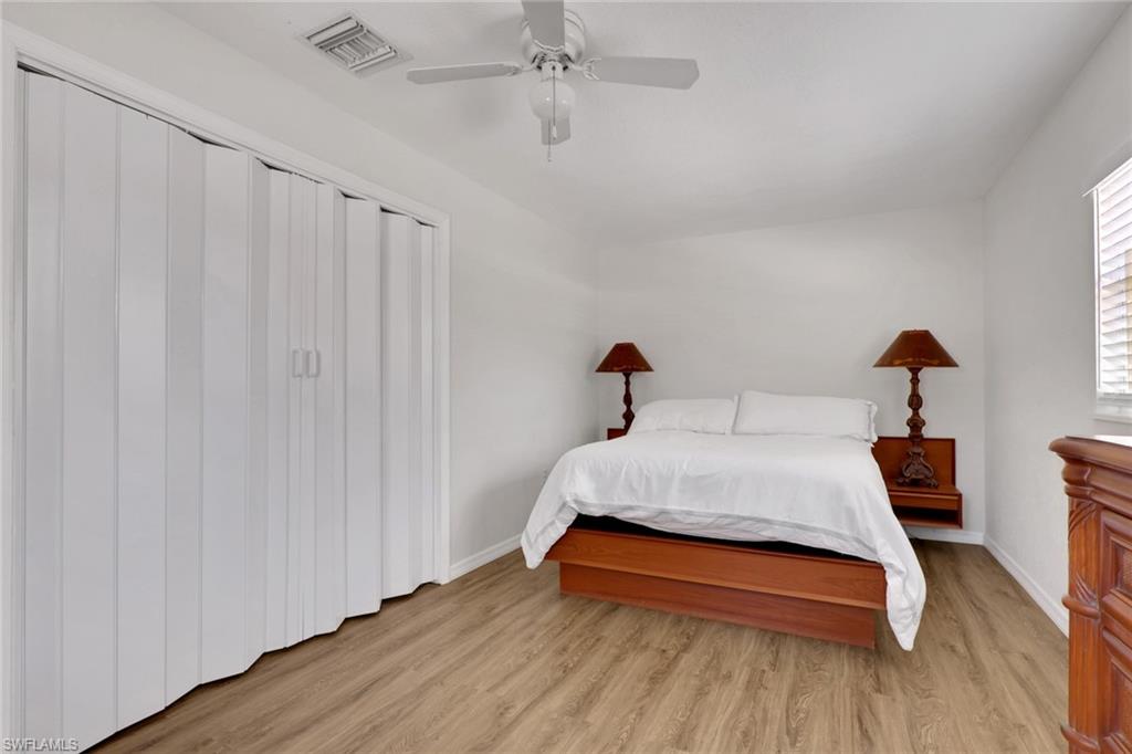 2772 Riverview Drive Naples, FL 34112 - Photo 13 of 23 a bedroom with a bed and wooden floor