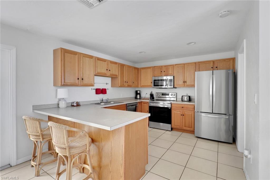 2772 Riverview Drive Naples, FL 34112 - Photo 2 of 23 a kitchen with stainless steel appliances a refrigerator sink and cabinets