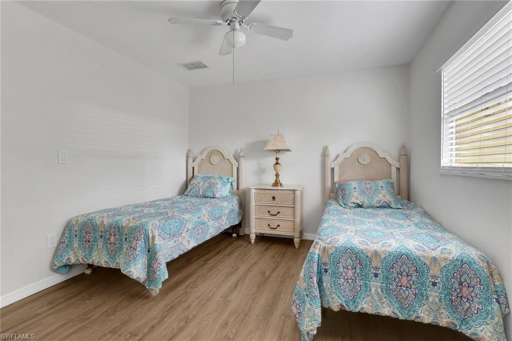 2772 Riverview Drive Naples, FL 34112 - Photo 22 of 23 a bedroom with a bed and wooden floor