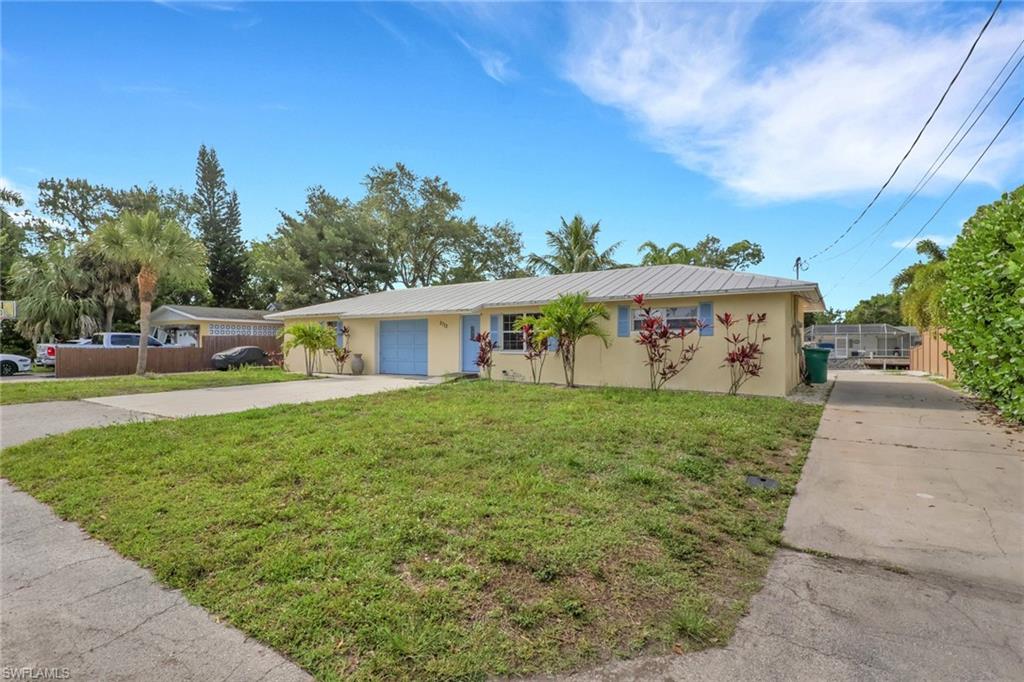 2772 Riverview Drive Naples, FL 34112 - Photo 23 of 23 a front view of a house with garden