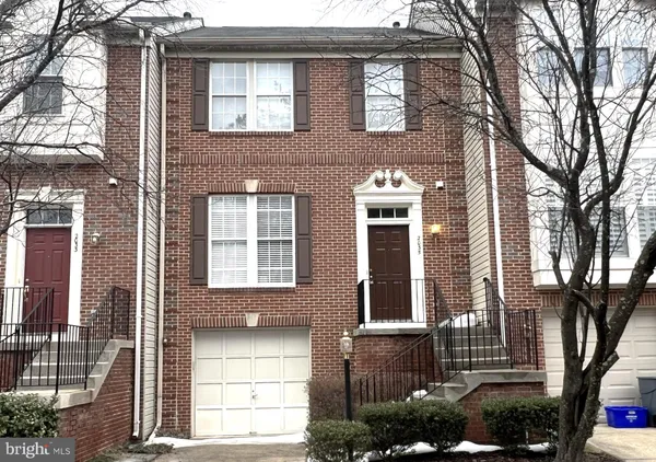 a front view of a house with a tree