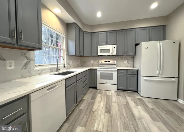 a kitchen with stainless steel appliances granite countertop a sink a stove and a microwave