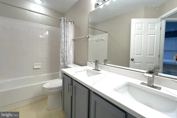 a bathroom with a double vanity sink toilet and a mirror