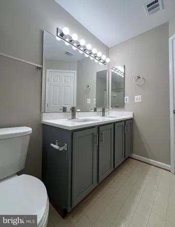 a bathroom with a sink a toilet a mirror and bathtub