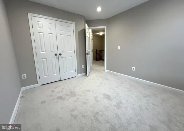 an empty room with windows and fireplace