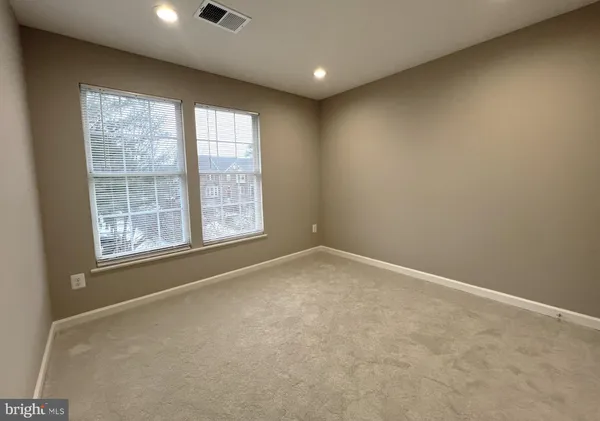 an empty room with windows fireplace and windows