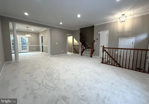 an empty room with chandelier garage and windows