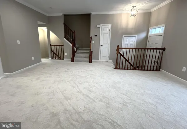 an empty room with chandelier garage and windows