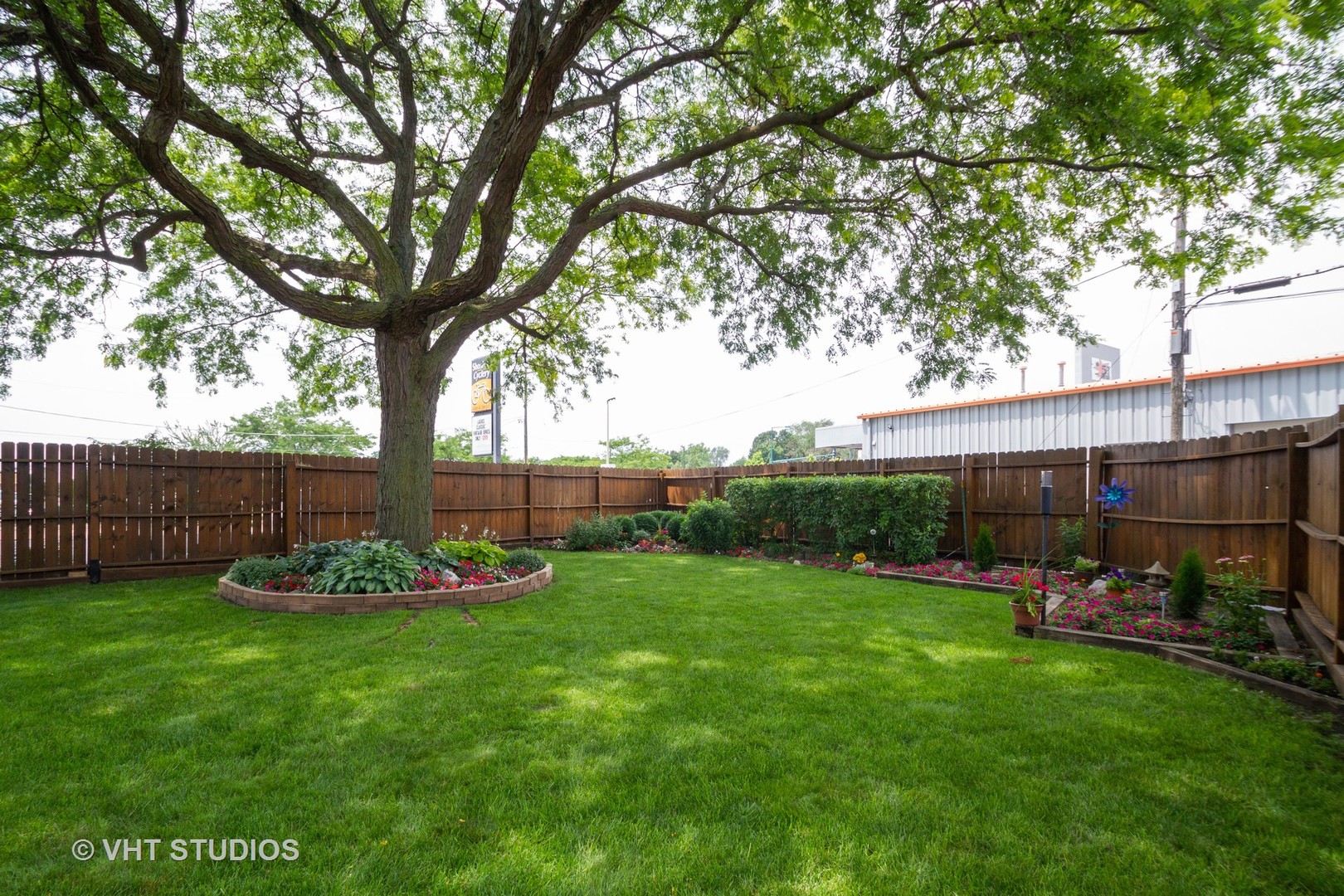514 Windsor Road Loves Park, IL 61111 - Photo 19 of 33 a view of a backyard with wooden fence and a large tree