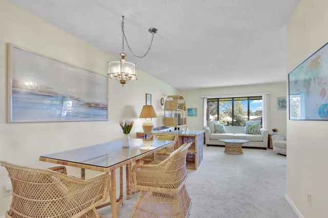 a living room with furniture a chandelier and a table