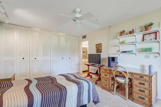 a bed room with a bed and a ceiling fan