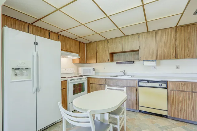 a kitchen with kitchen island a white cabinets and refrigerator